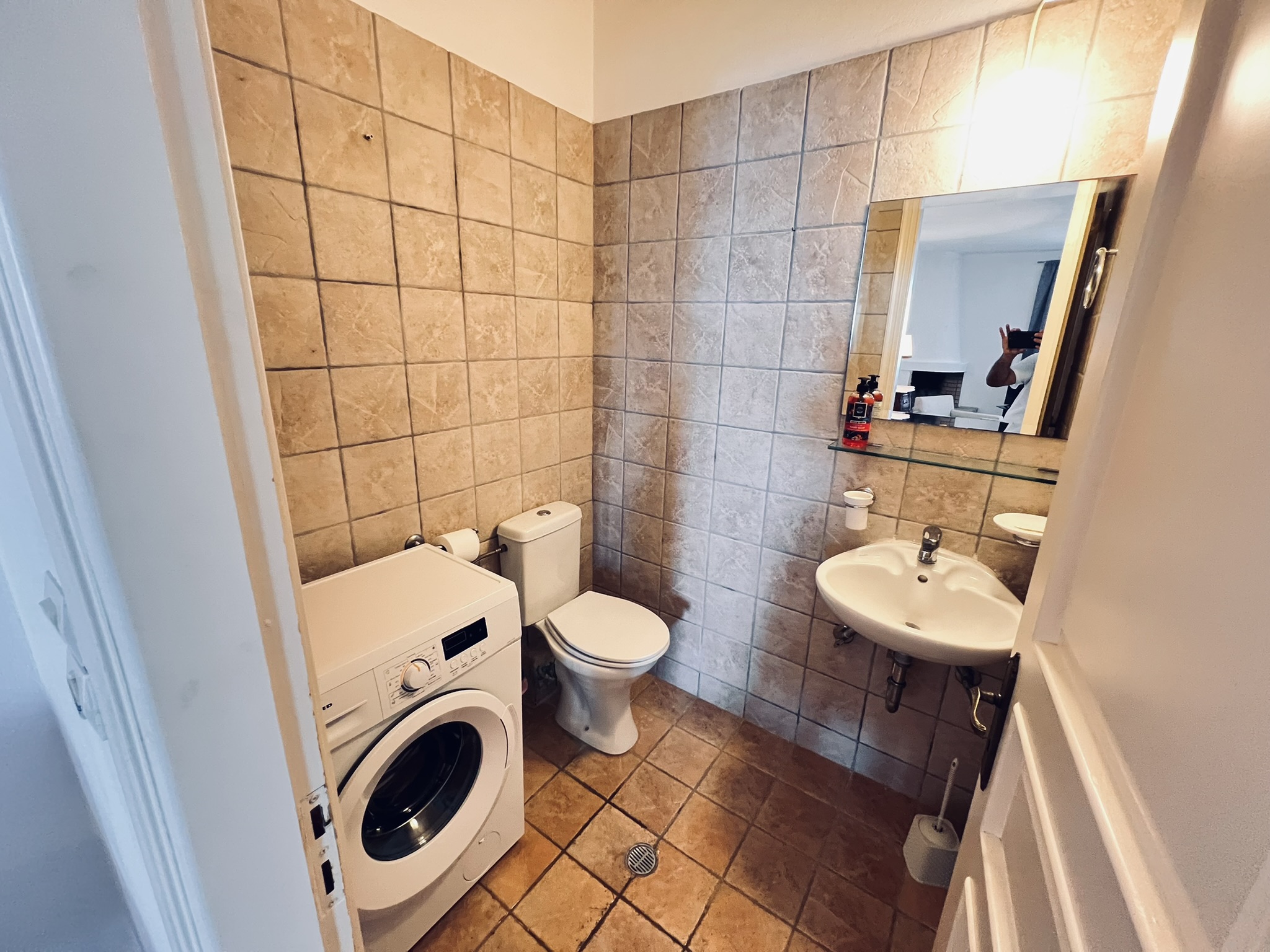 The ground-floor WC with washing machine, basin, and mirror