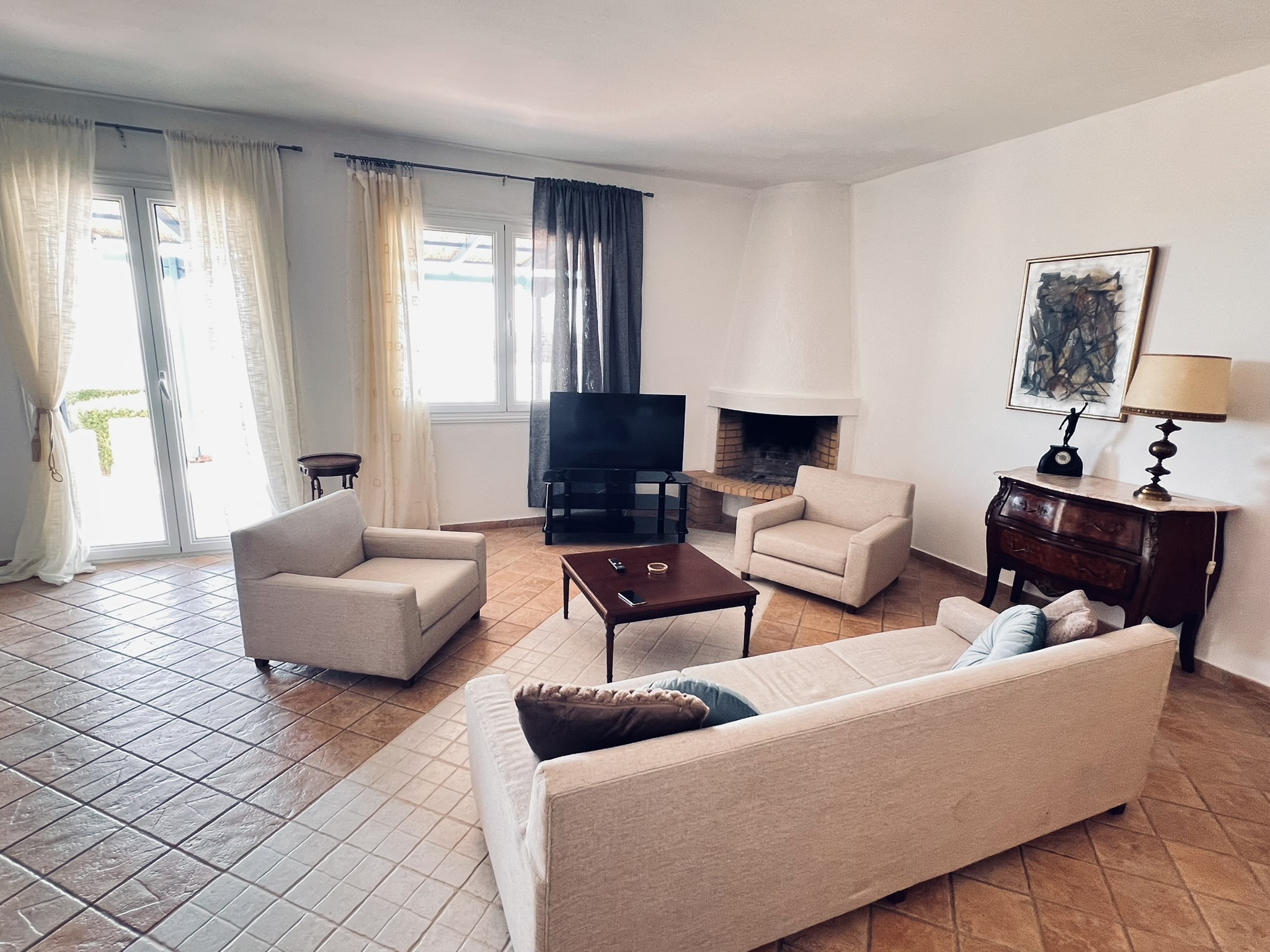 The open-plan living room — seating, fireplace, and dining table